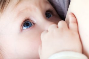 wide-eyed baby sucking breast