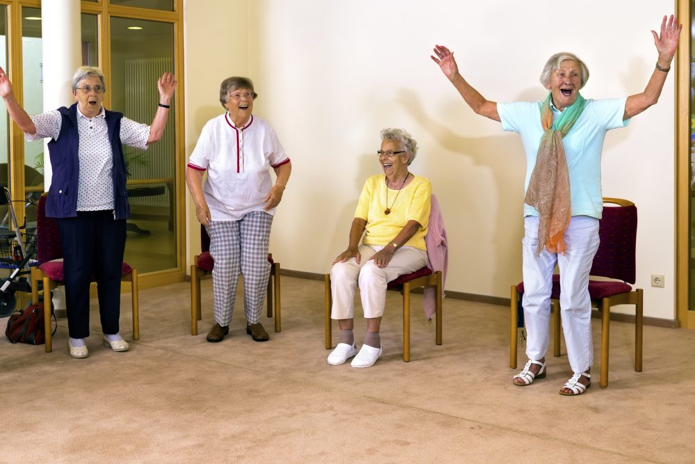 Senior women standing and sitting for exercise.