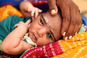 Indian woman holding her child in desert village, Rajasthan