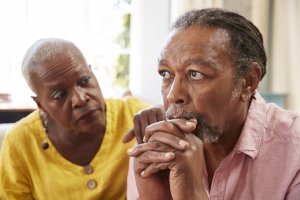 depression: older woman comforting a man